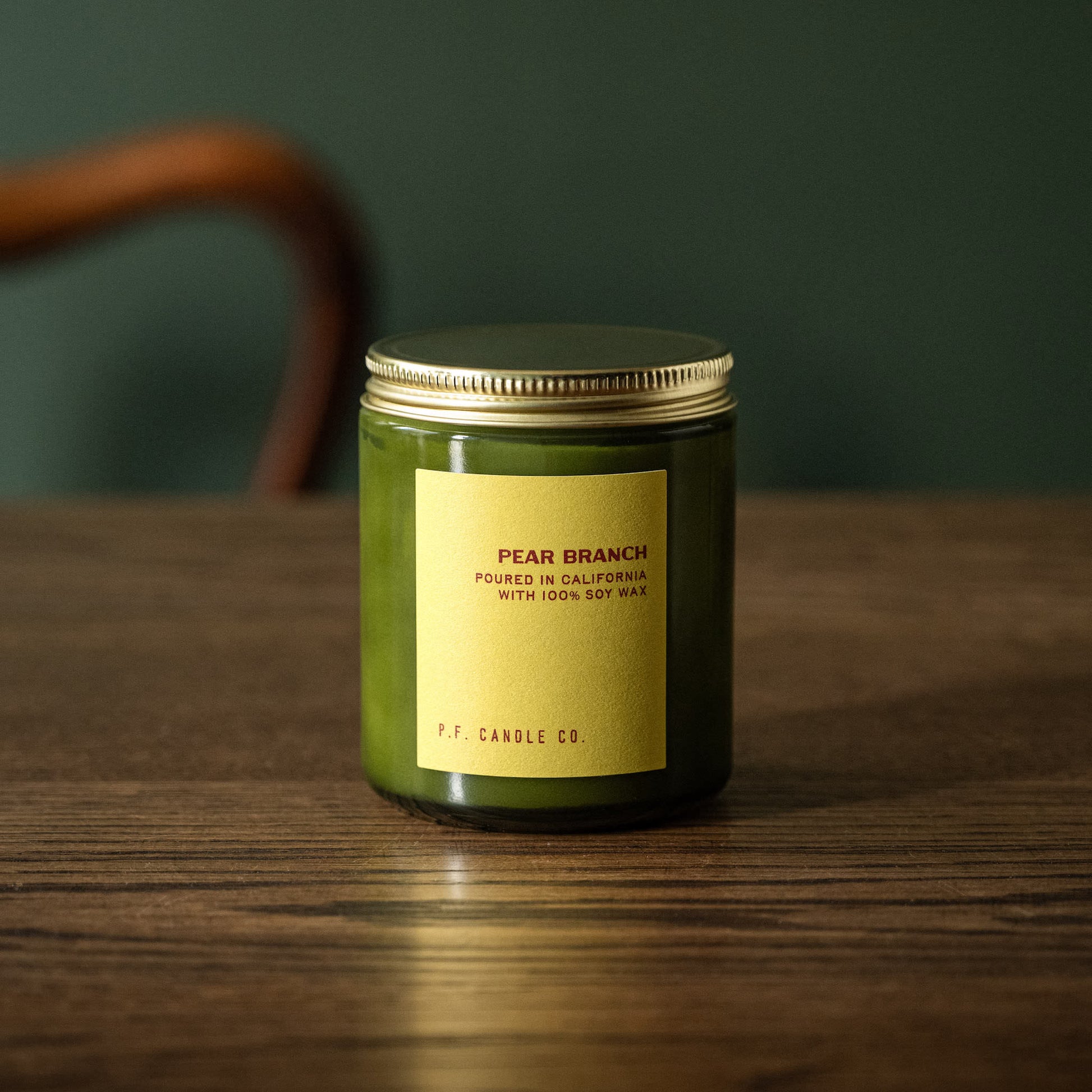 PF Candle Co "Pear Branch" scented candle in a green glass jar with a gold lid 