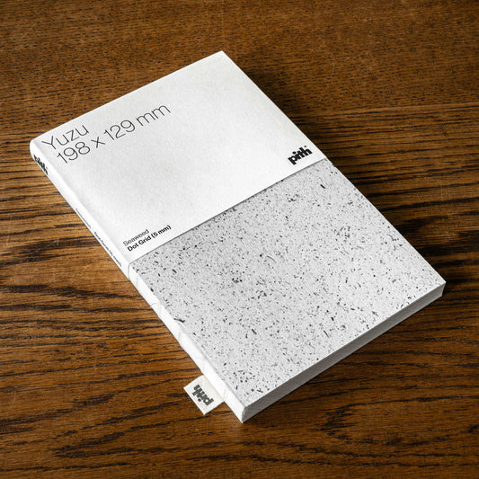 Pith Supply Yuzu Dot Grid notebook with a flexible Notpla seewead cover. The is 198mm x 129mm and the seaweed cover is light grey speckled.