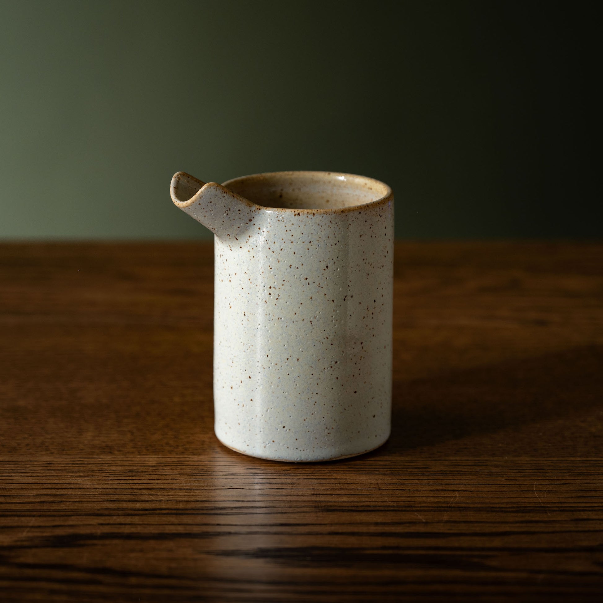Pottery West powder blue stoneware pourer on a wooden table