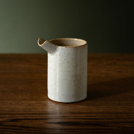 Pottery West powder blue stoneware pourer on a wooden table