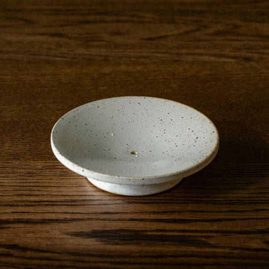 Pottery West circular stoneware soap dish in speckled white with drainage hole