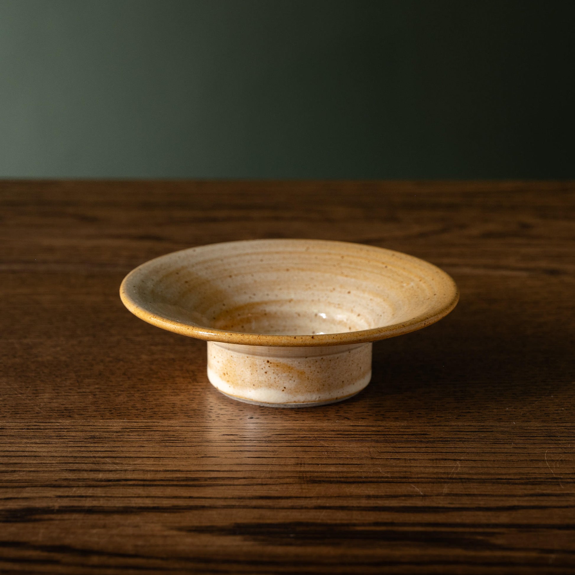 Pottery West sand flecked stoneware stumpie candle holder on a wooden table