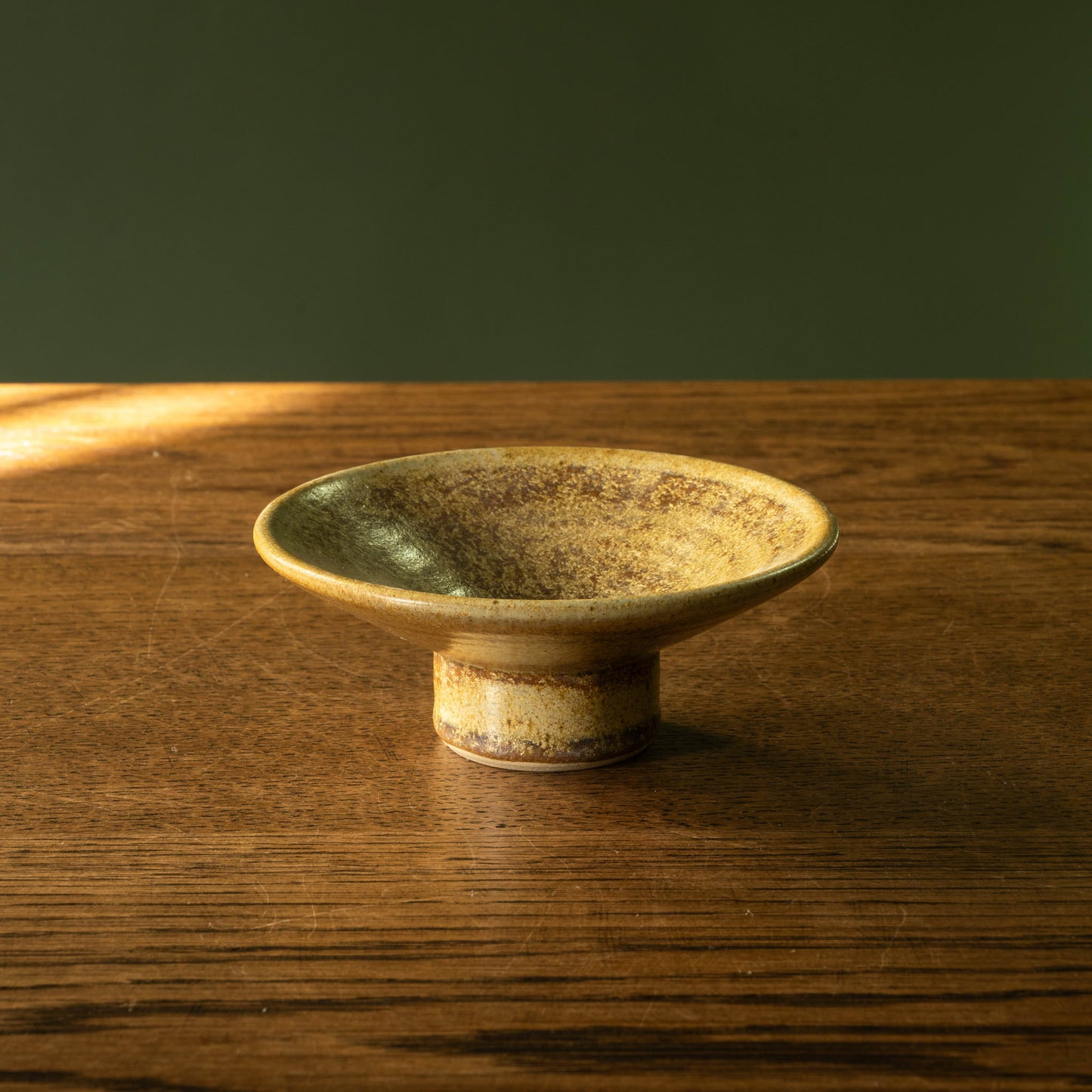 Pottery West stoneware candle holder in ochre glaze showing the side view.