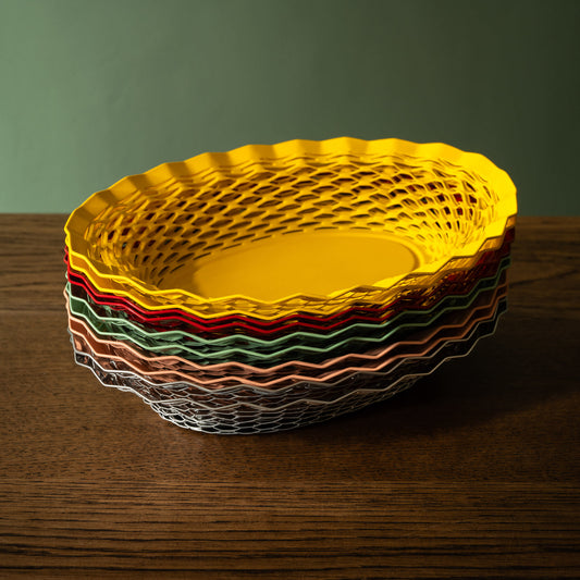 Stainless steel oval bread baskets stacked on top of each other in various colours