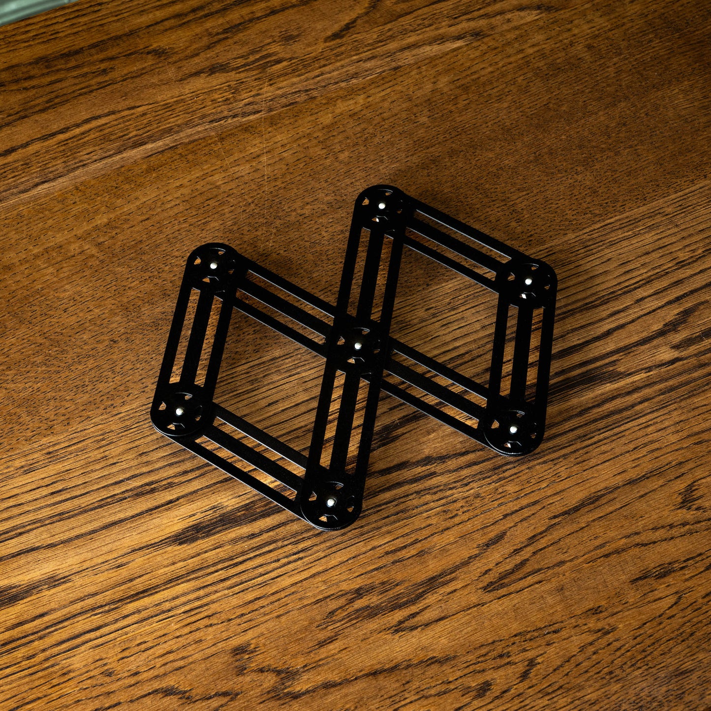 Stainless steel trivet in black, partially extended 