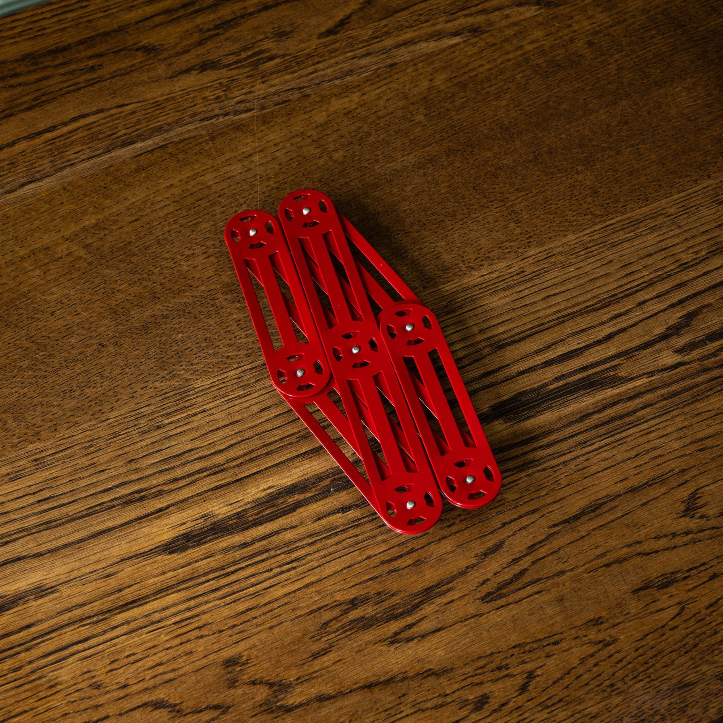 Stainless steel extending trivet fully closed in red 