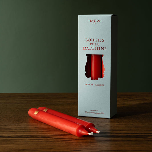 Trudon Madeleine red brick taper candles with Trudon packaging box on a wooden surface