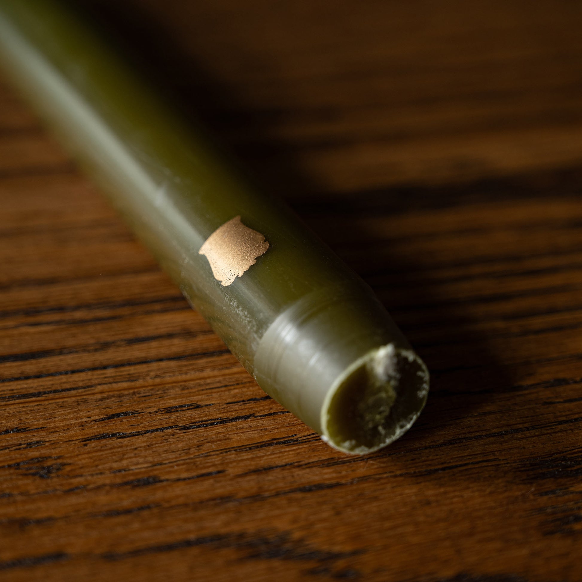 Close-up of Trudon Khaki Madeleine taper candle base 