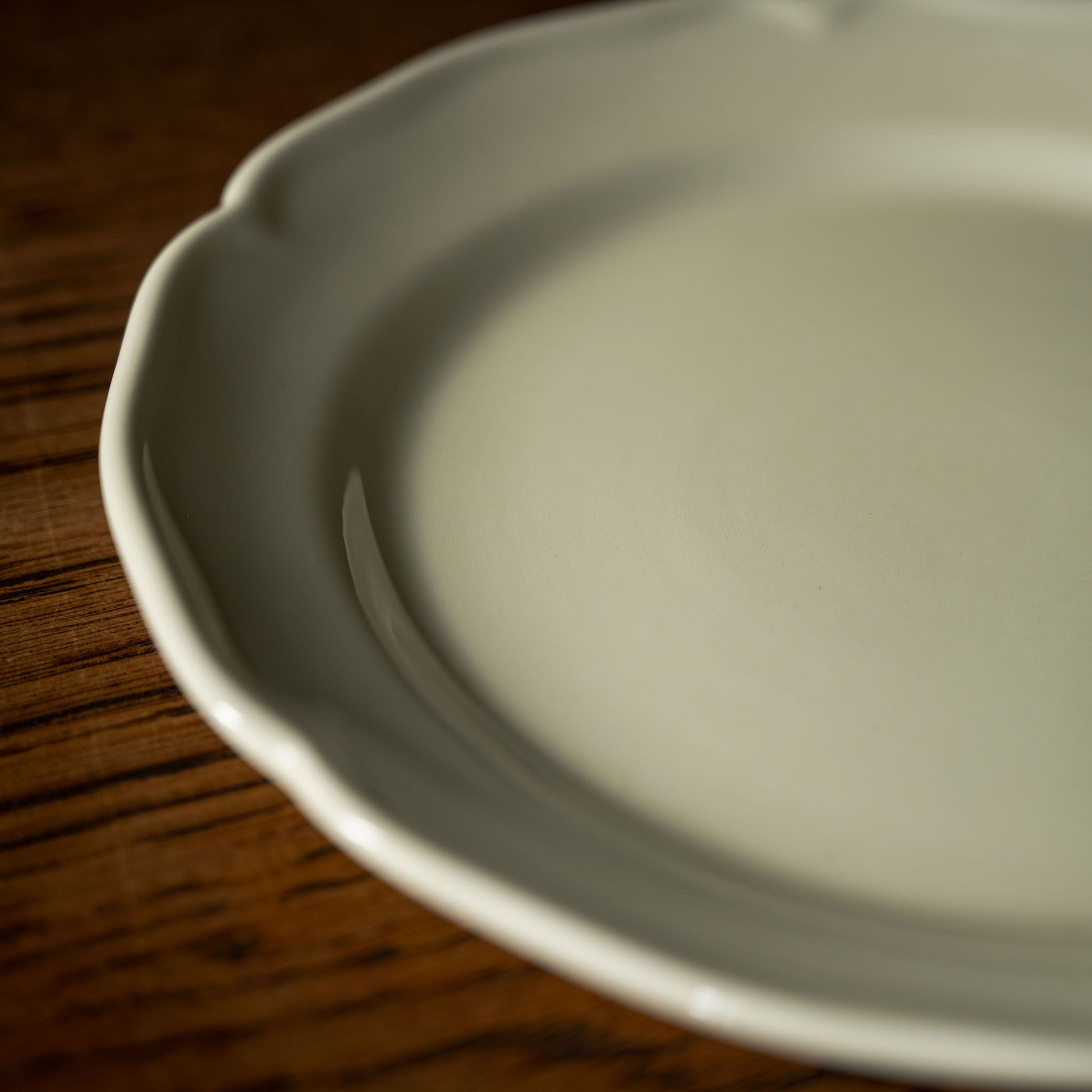 Close up of the scalloped rim design of the cream side plate