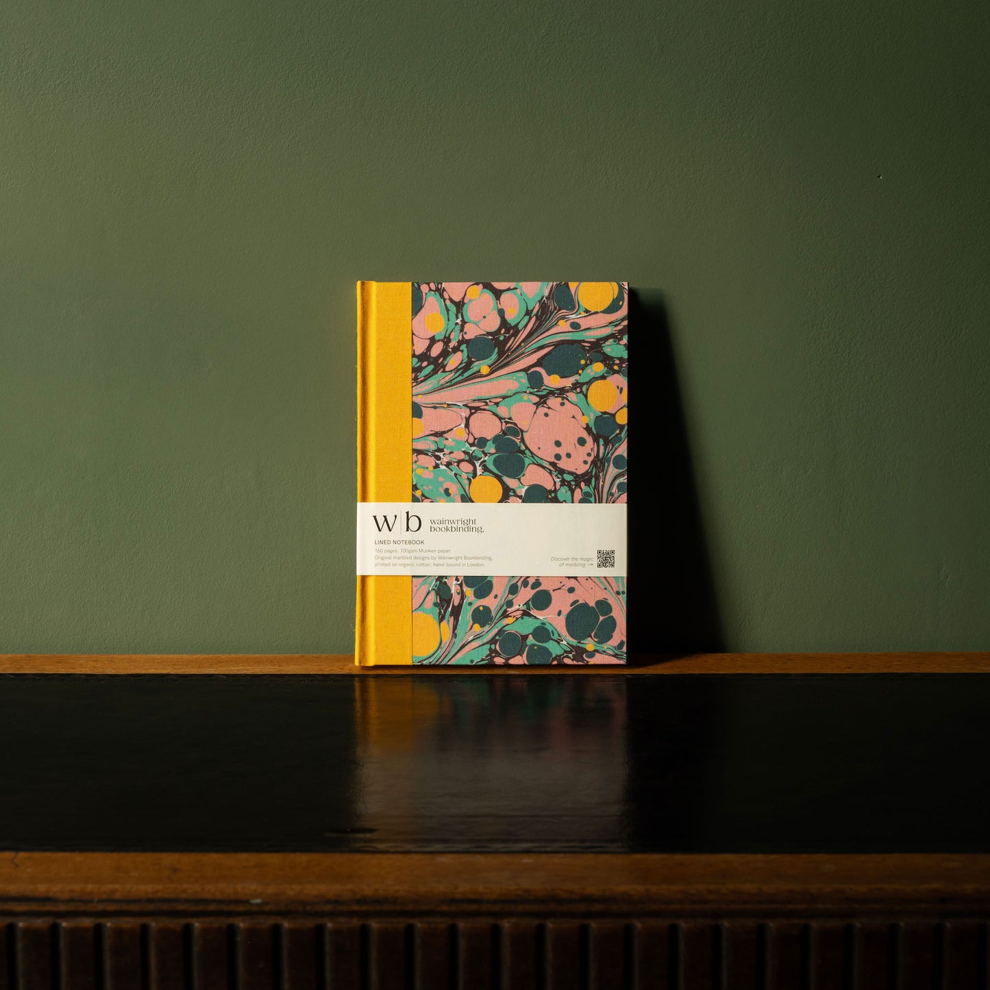 Wainwright Bookbinding notebook with a yellow, pink & green marbled fabric design 